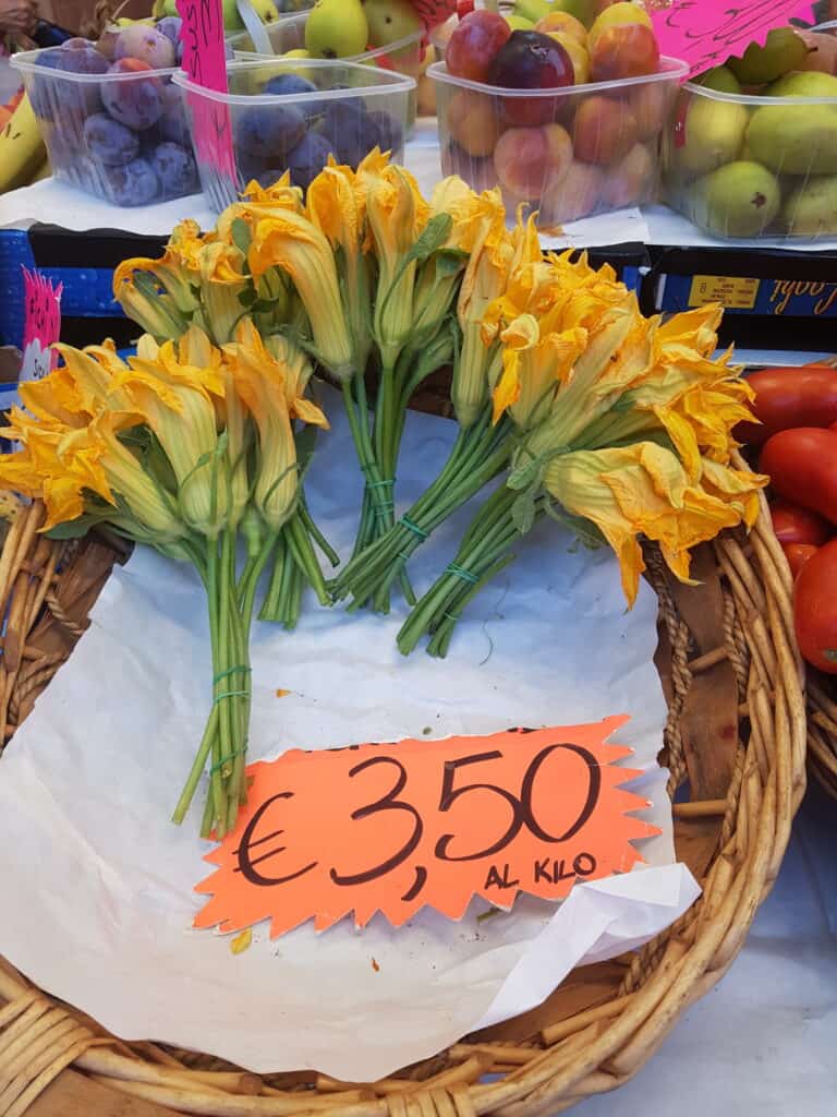 Bunches of male courgette flowers at a market in Italy.