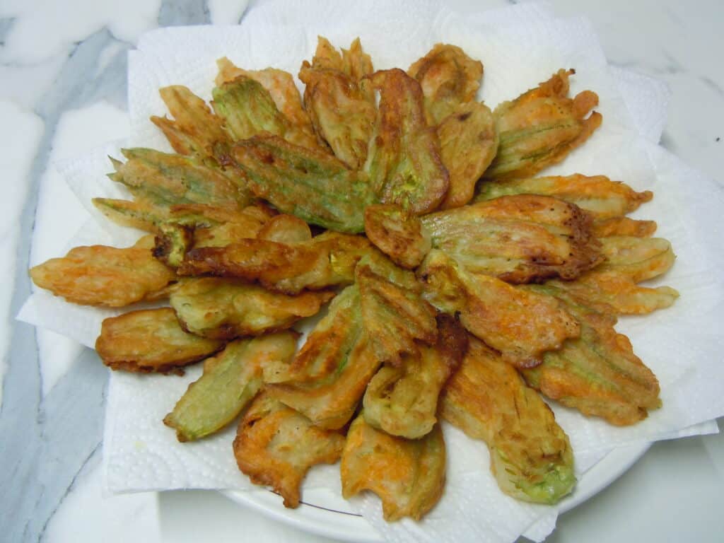 Courgette flowers fried in beer batter on some absorbent kitchen paper