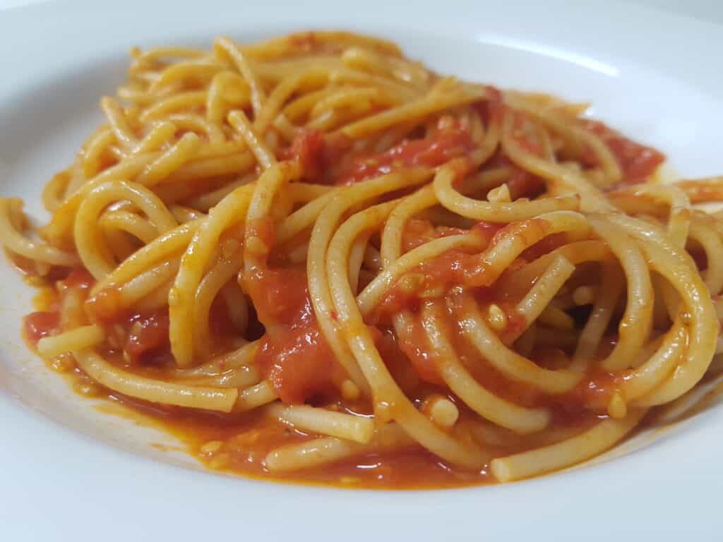 spaghetti with homemade fresh tomato pasta sauce on a white plate