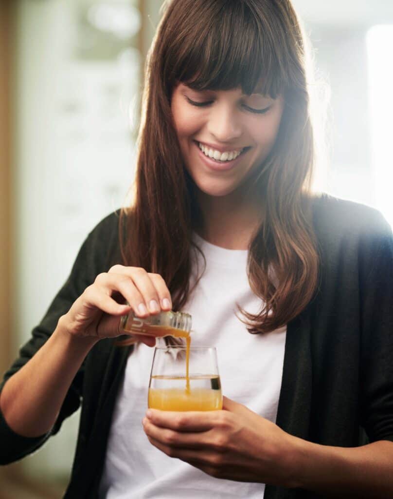 A model holding a glass of Ringana chi diluted in water.