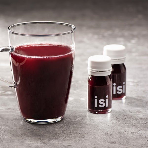 A glass of Ringana isi drink with two bottles of Ringana isi.