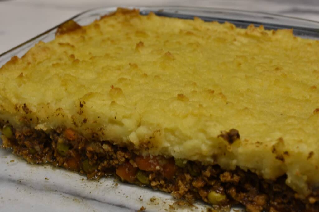 Close up of a vegan shepherd's pie in a transparent Pyrex oven dish