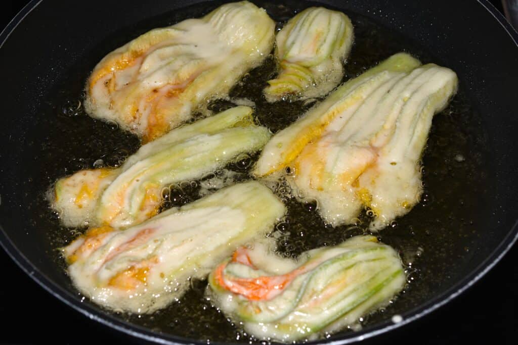 Courgette (zucchini) flowers shallow frying in a pan.