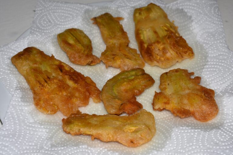 Shallow fried courgette flowers on absorbent kitchen paper.