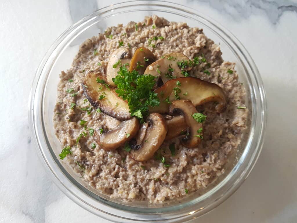 Vegan mushroom paté in a round glass dish on a kitchen counter