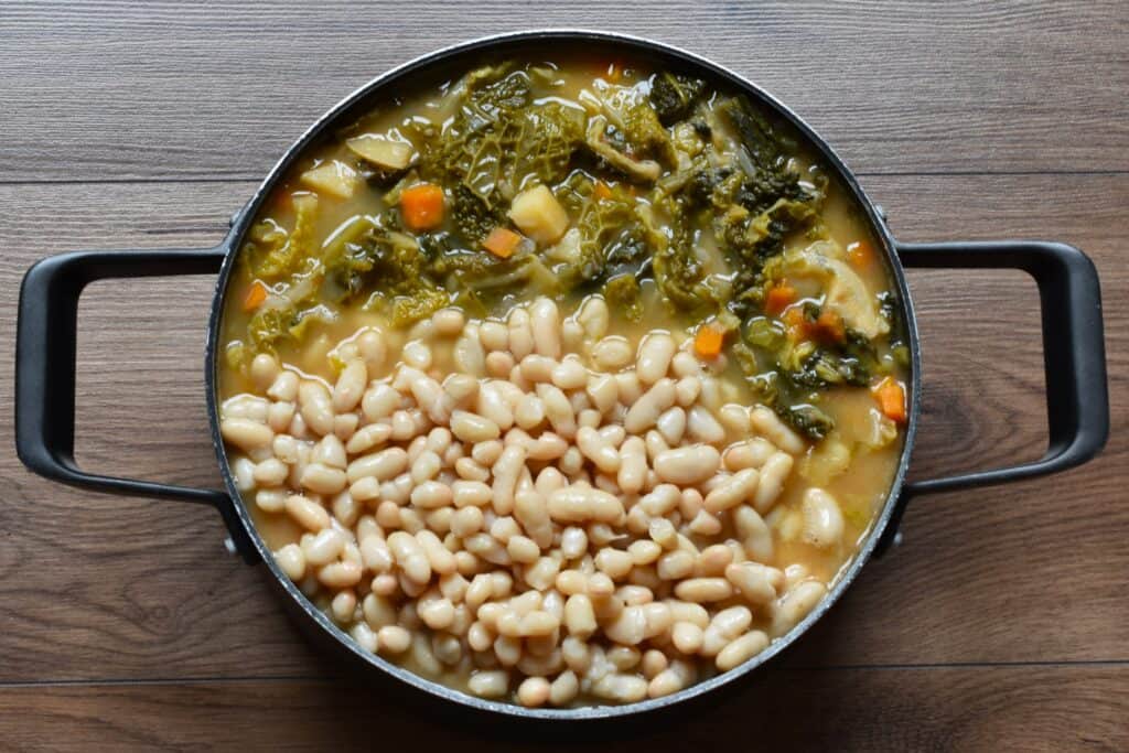 Add whole cannellini beans to the Tuscan ribollita soup (ribollita toscana).