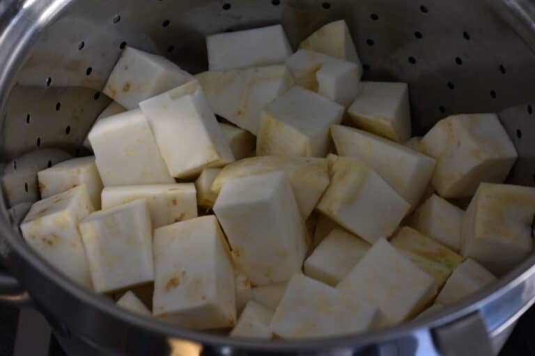 Cubes of raw celeriac in a steamer basket