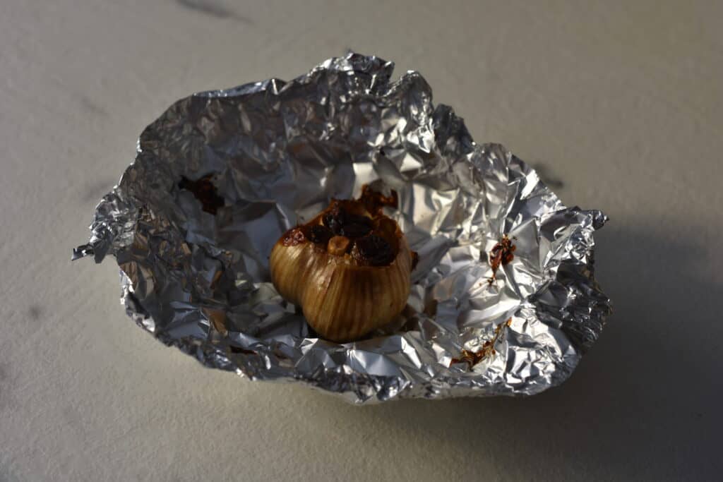 A head of roasted garlic in aluminium foil