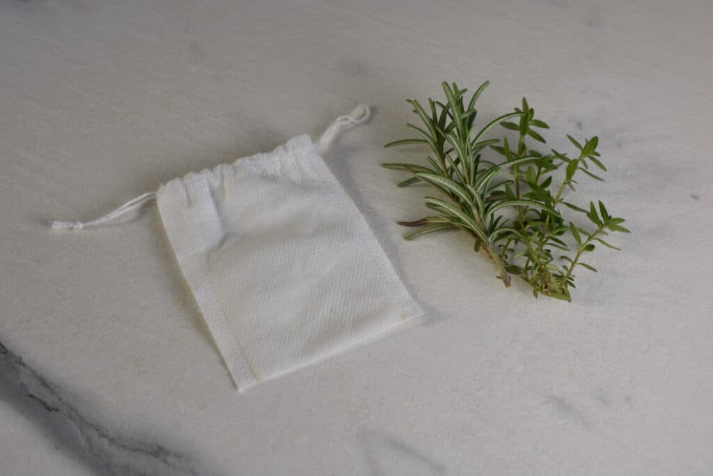 A herb bag with sprigs of rosemary and thyme on a kitchen worktop