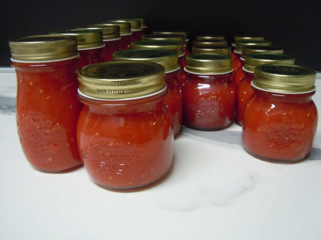 Jars of homemade tomato sauce on kitchen worktop