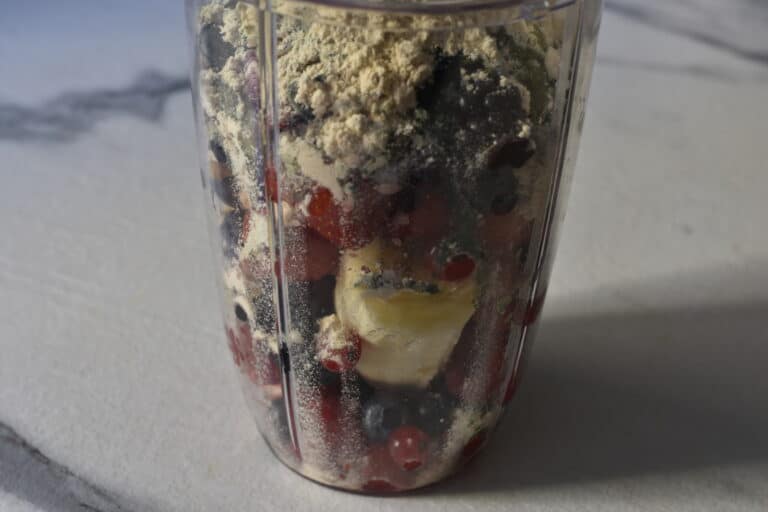 Mixed berries and superfood ingredients in a blender beaker