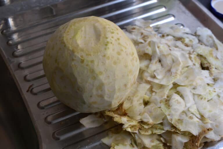 Peeled celeriac on a kitchen draining board with the peelings 