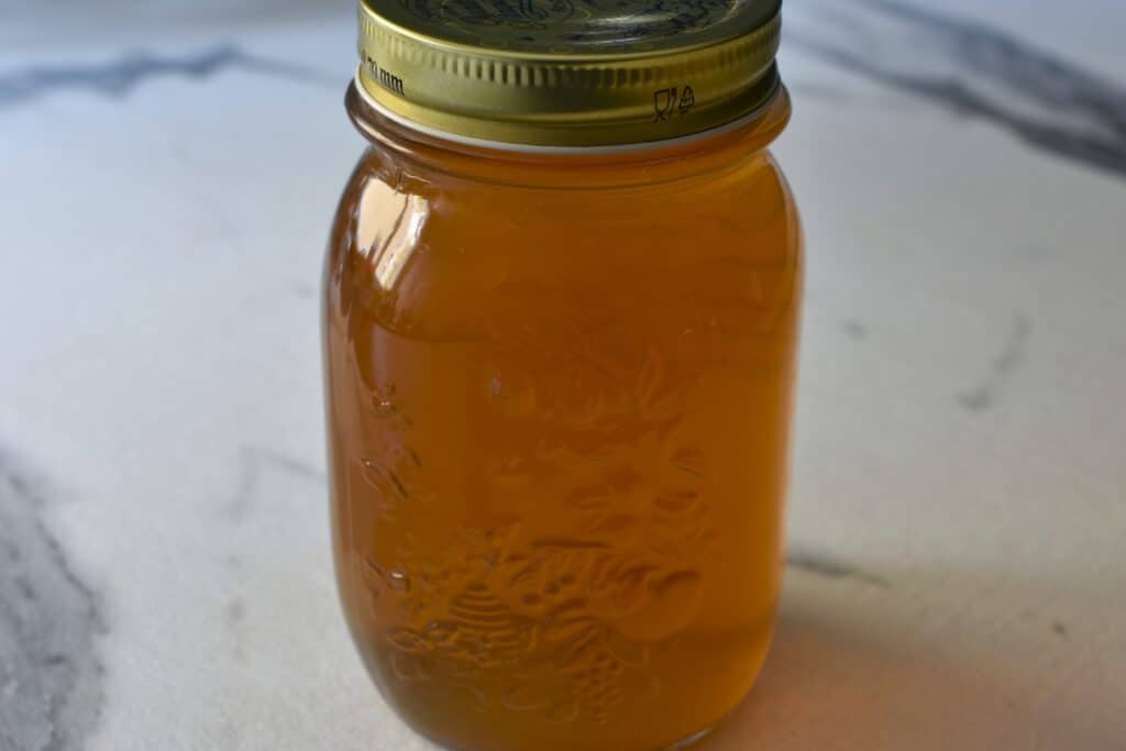 A jar of homemade vegetable broth made from kitchen scraps.