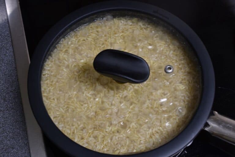 Brown basmati rice steam-cooking in a pan with a lid on