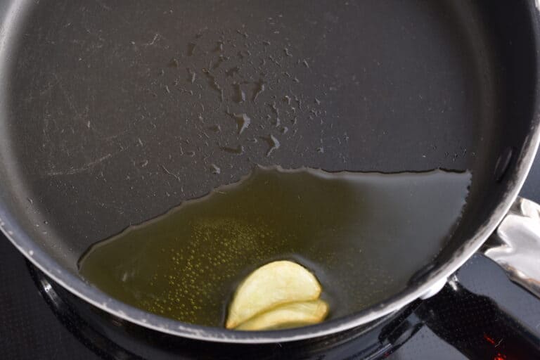 A clove of crushed garlic, gently sautéed on low heat until golden.