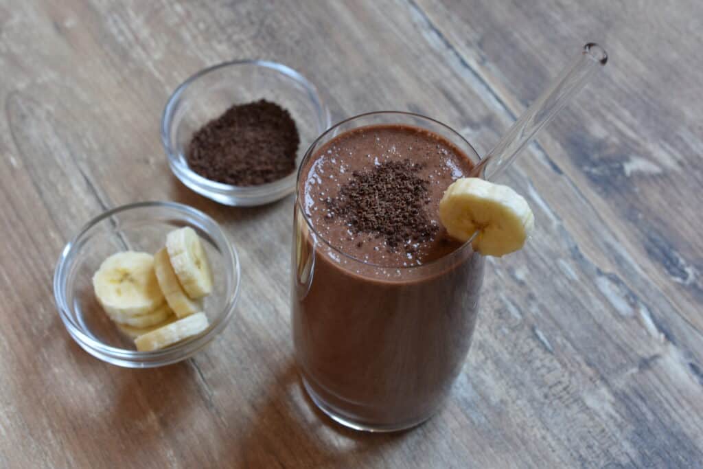 A glass of vegan chocolate banana protein shake.