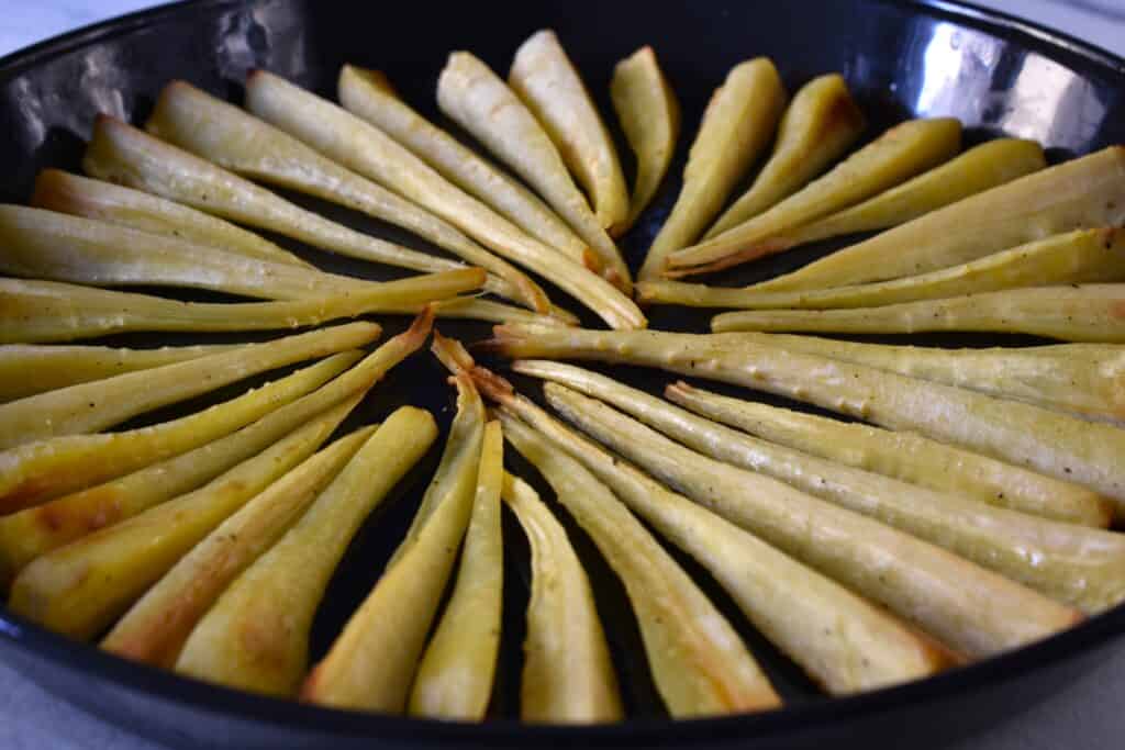 Close-up image of oven-roasted parsnip chips on an oven tray