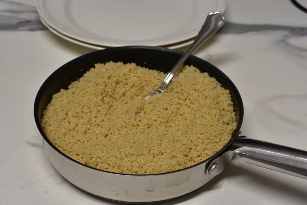 Couscous fluffed up with a fork