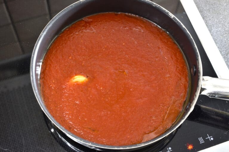 Tomato sauce and a clove of garlic in a pan