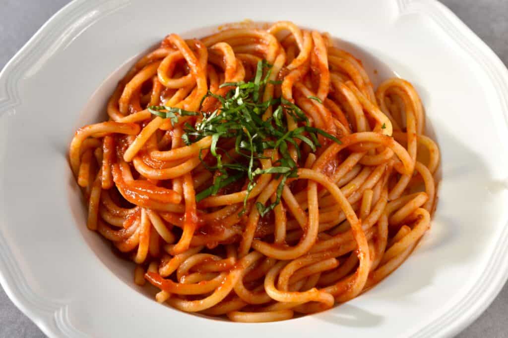 Spaghetti with fresh tomato pasta sauce and fresh basil julienne