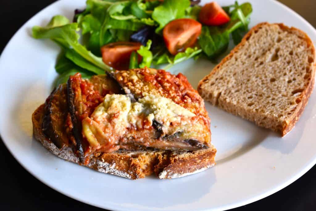 Vegan aubergine parmigiana on a slice of sourdough bread