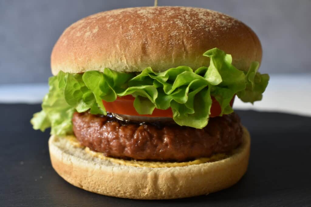 A vegan fast food burger on a grey platter.