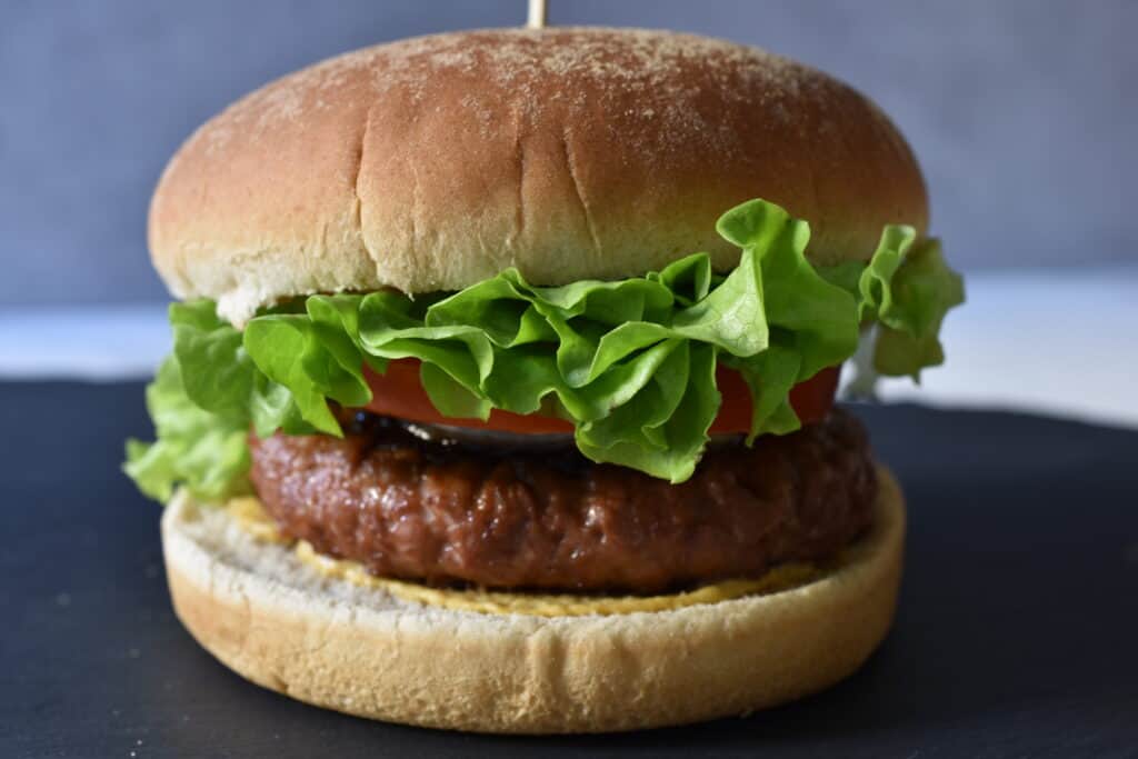 A vegan fast food burger on a grey slate.