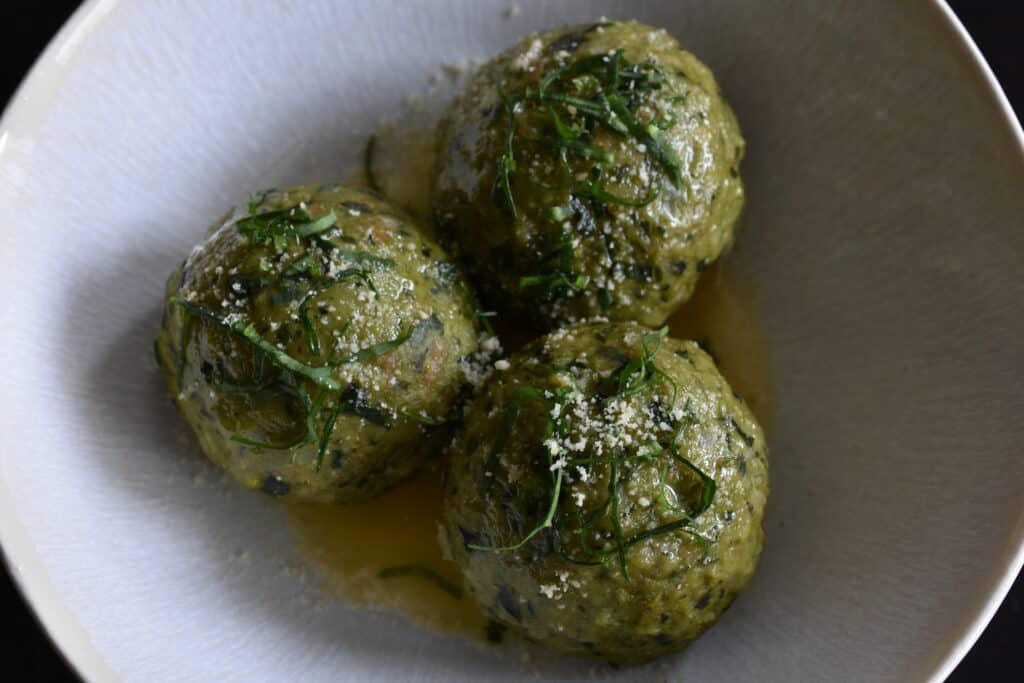 Canederli all'aglio orsino (Italian wild garlic bread dumplings in a white bowl