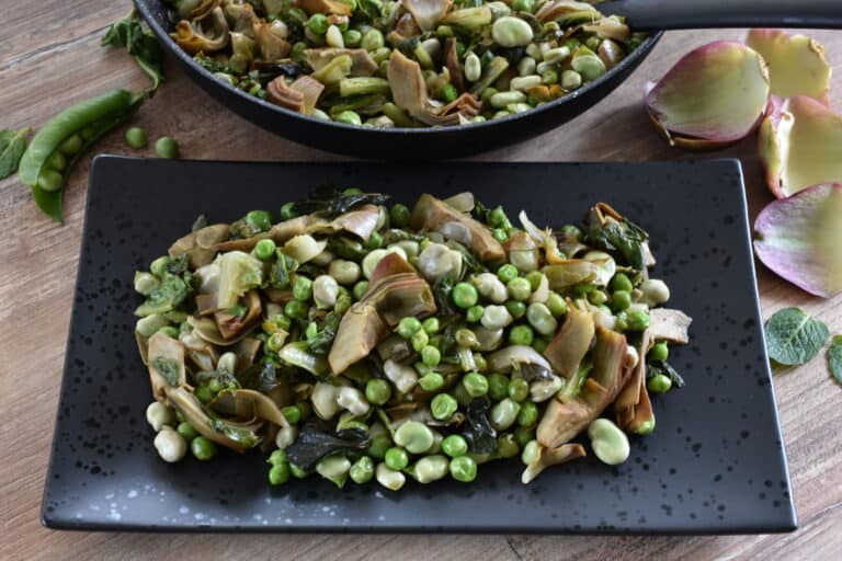 Close-up image of vignarola on a black serving plate