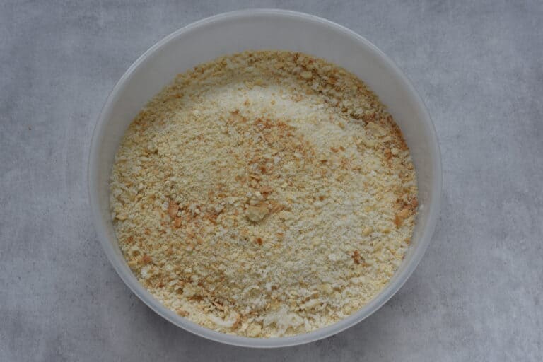 Dry breadcrumbs in a white plastic bowl on a kitchen worktop.