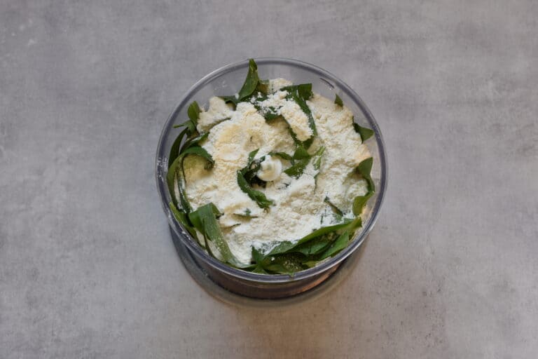 Flour and wild garlic leaves in a food processor.