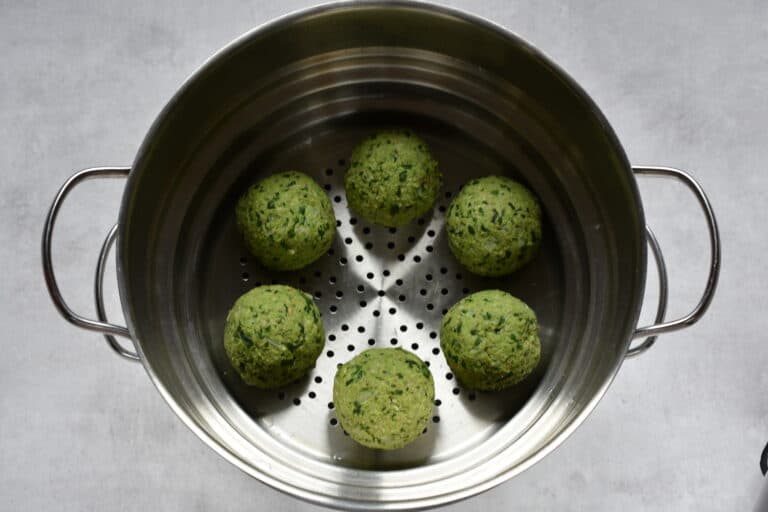 Raw vegan wild garlic dumplings in a steamer.