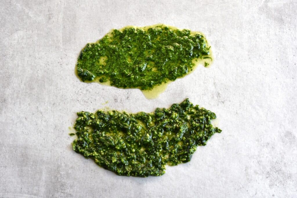 Vegan wild garlic pesto made with a mortar and pestle (top) and a food processor (bottom), spread out on a kitchen worktop for comparison.