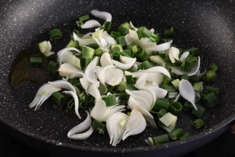 Spring onions in a pan with olive oil.