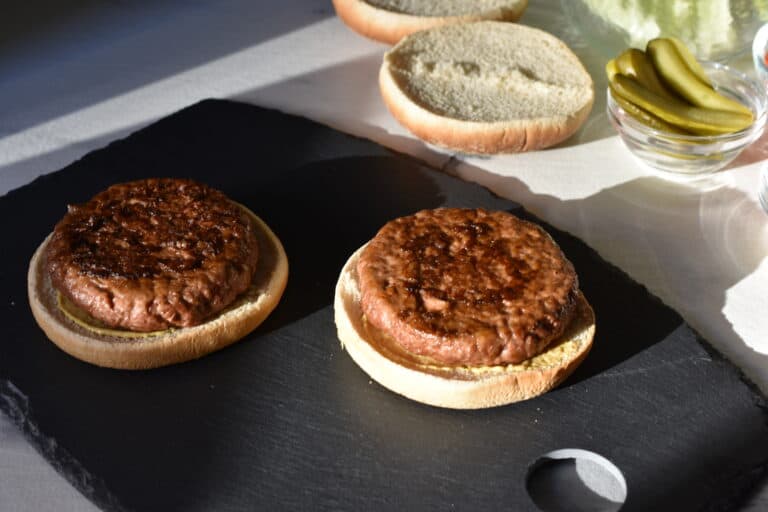 Toasted vegan burger buns with mustard and a vegan fast food burger.