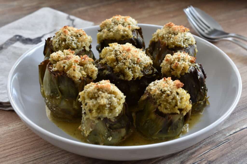 Vegan stuffed artichokes on a white plate.