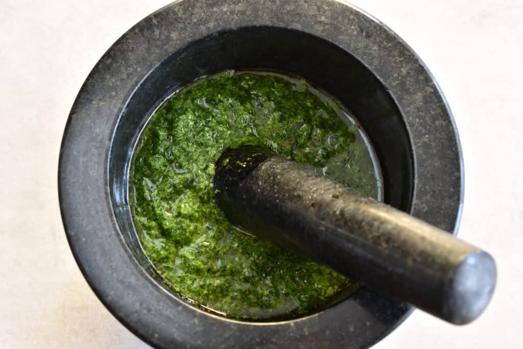 Vegan wild garlic pesto in a mortar with a pestle.