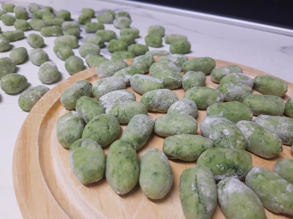 Raw wild garlic gnocchi on a kitchen worktop.