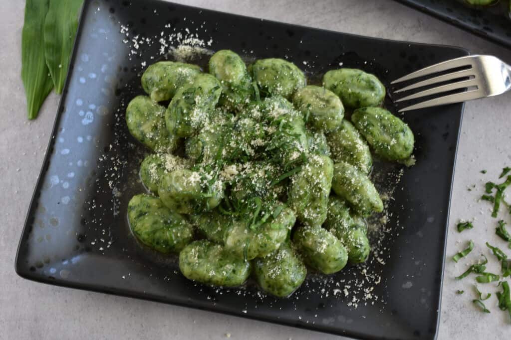 Wild garlic (ramsons) gnocchi on a black plate