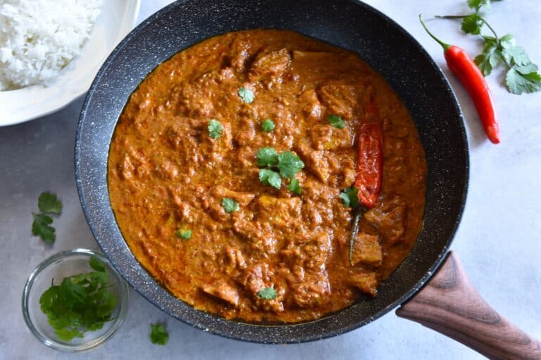 A pan of vegan chicken tikka masala on a kitchen worktop.