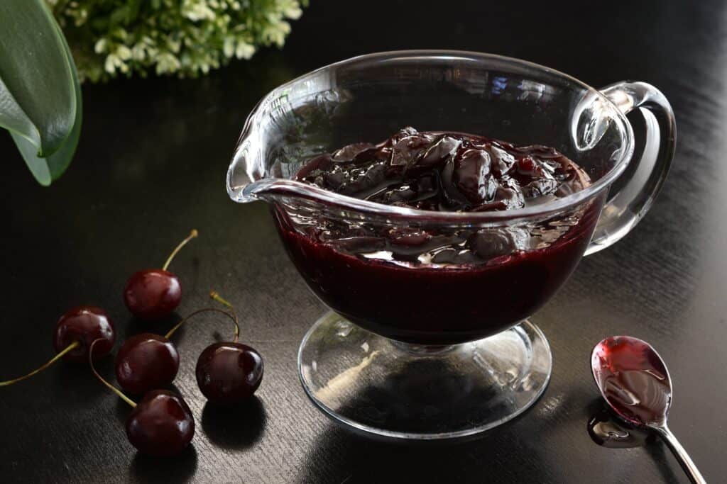 Cherry sauce for desserts in a glass sauce boat