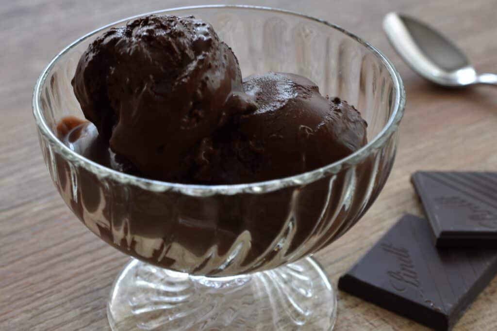 Close-up image of vegan dark chocolate ice cream in a glass bowl.