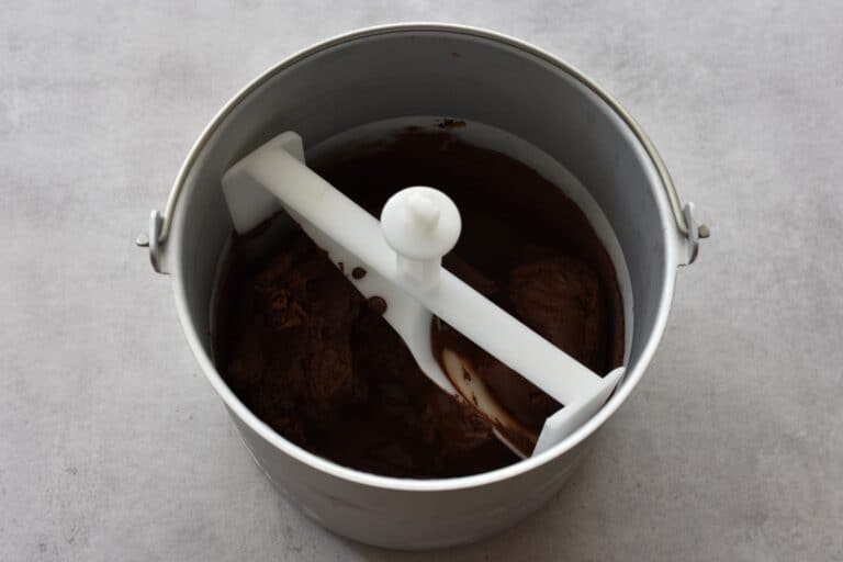 Vegan dark chocolate ice cream in the basket of an ice cream maker.