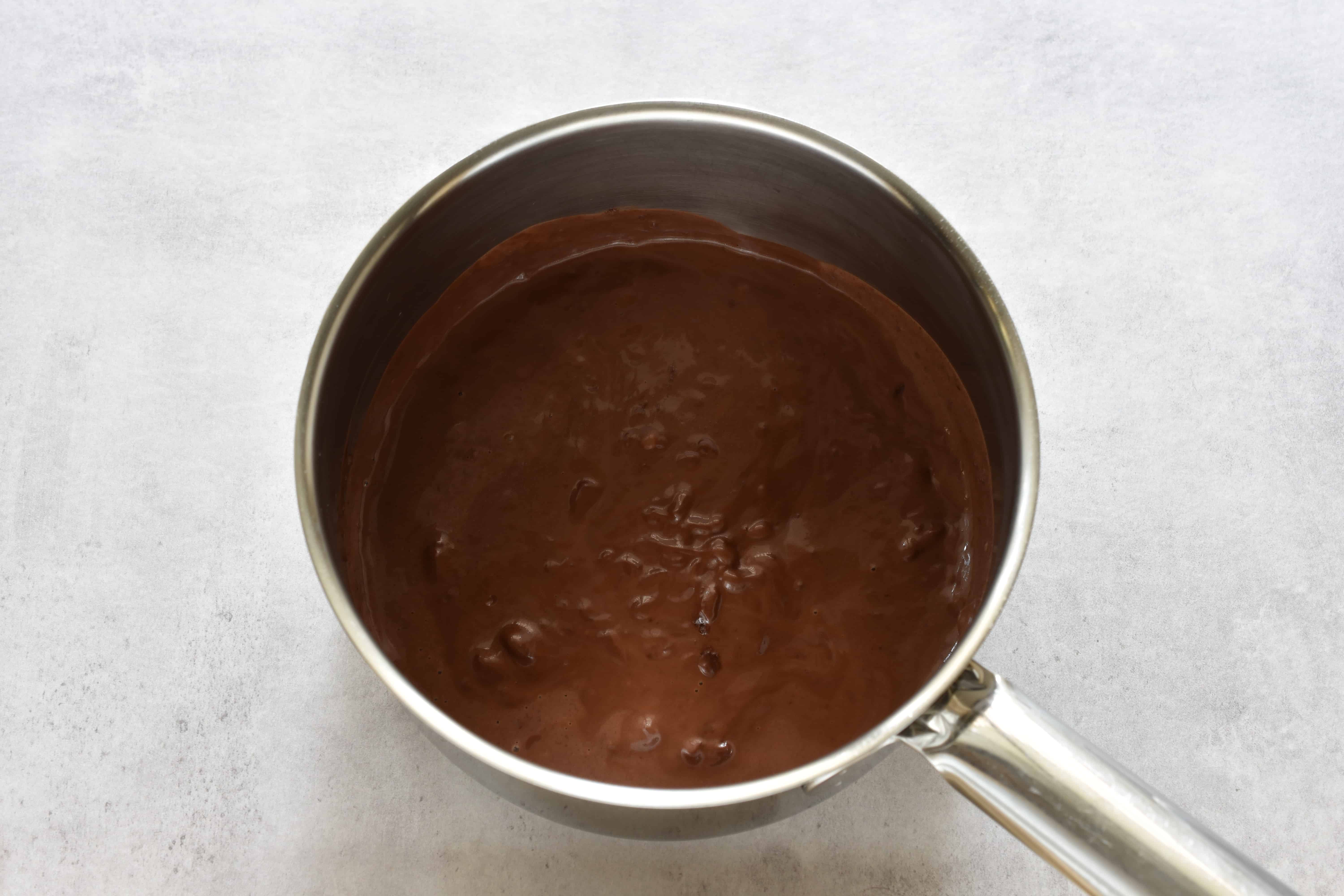 Vegan melted dark chocolate and plant-based milk in a saucepan.