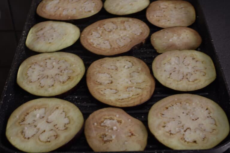 Aubergine slices on a grill pan with a sprinkling of unrefined sea salt.