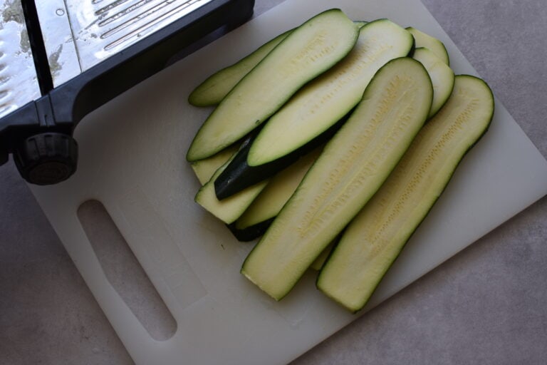 Courgettes (zucchini) sliced lengthwise on a mandolin.