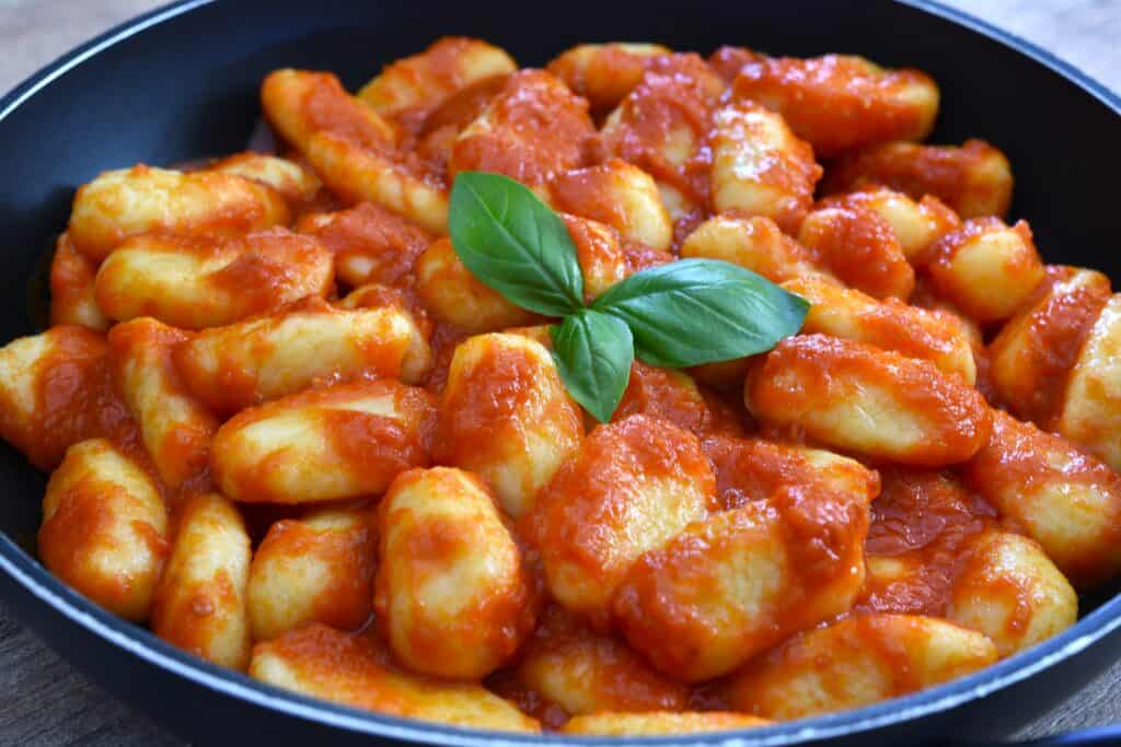 A pan of potato gnocchi with homemade fresh tomato sauce.