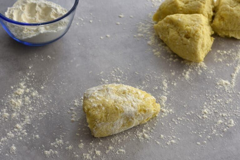 Take a piece of gnocchi dough and sprinkle it with flour.