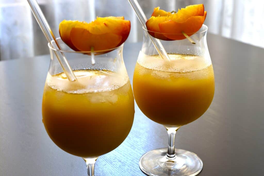 Two glasses of pick-me-up fruit cocktail with fresh fruit garnish