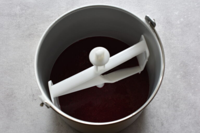 Concord grape sorbet mixture in the basket of an ice cream maker.